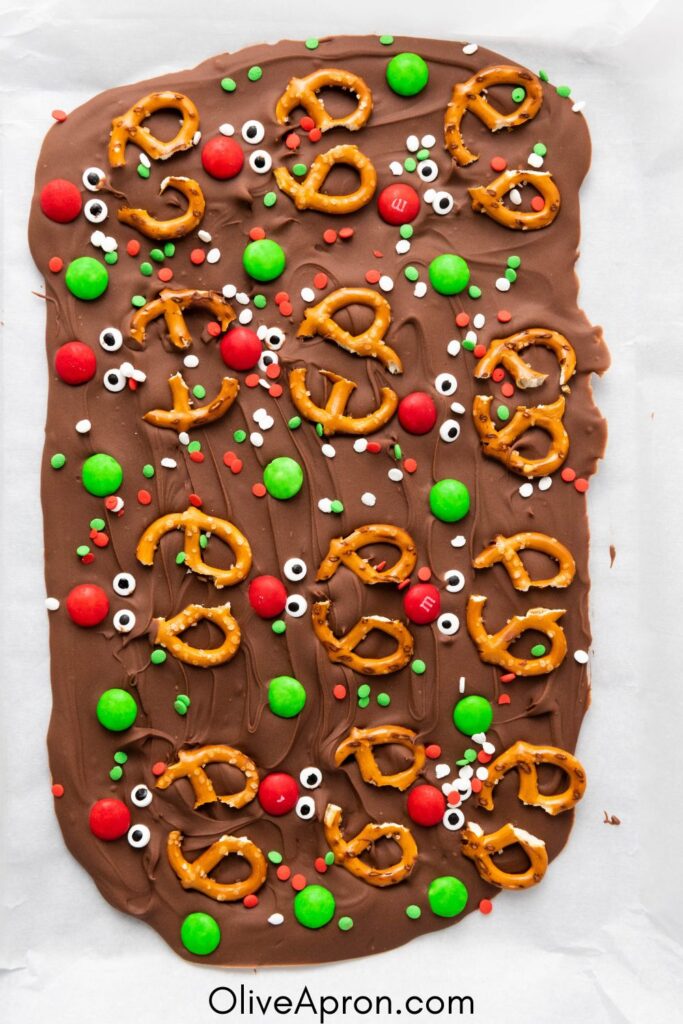 Christmas chocolate bark topped with pretzels, candies, and festive sprinkles.