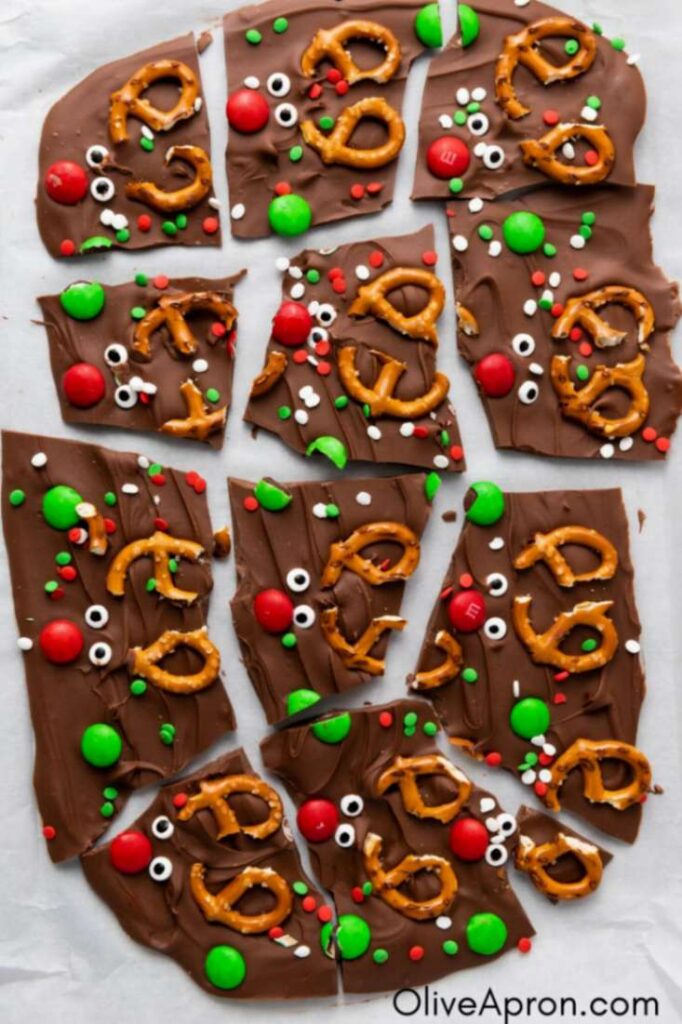 Christmas chocolate bark with pretzels, candies, and sprinkles broken into pieces.