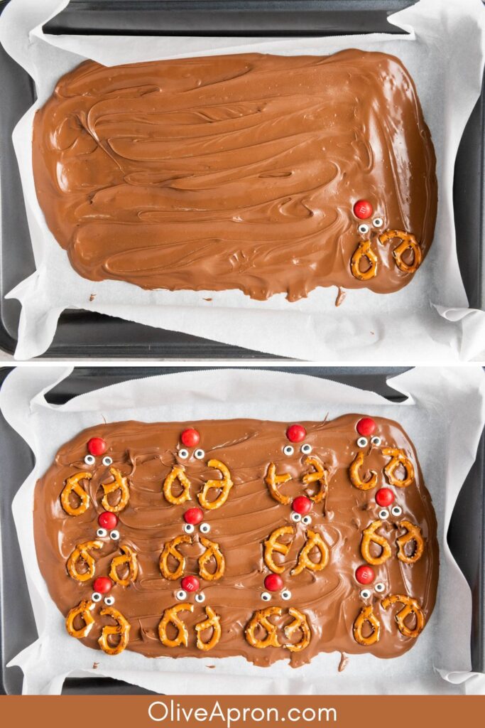 Melted chocolate bark on a tray being decorated with pretzels, candy eyes, and red candies.