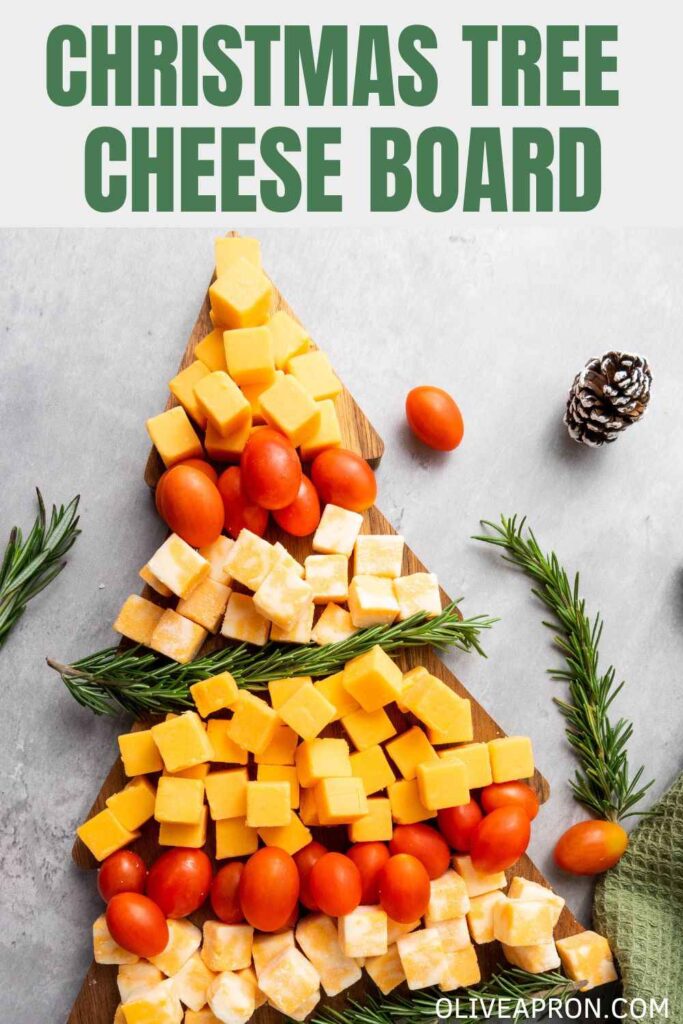 Christmas Tree Cheese with rosemary springs over a Christmas tree board. and a grey background.