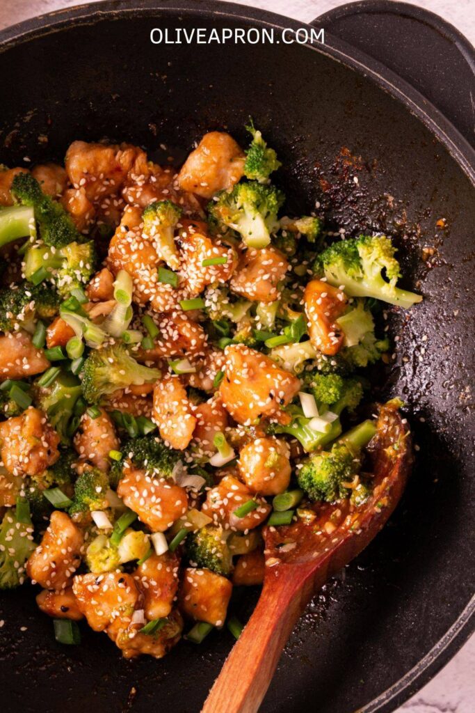 Easy honey garlic chicken and broccoli served on a plate with sesame seeds and scallions.