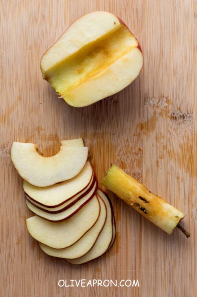 Sliced apples on a cutting board, ready to be used for homemade upside-down apple tarts.