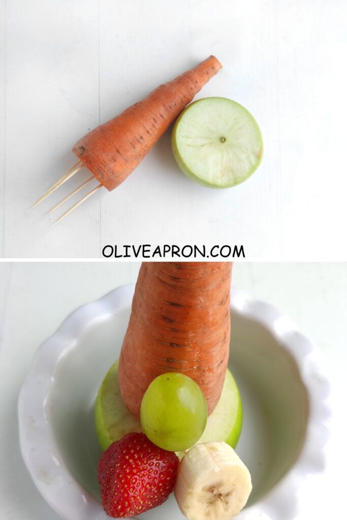 Base of a Christmas fruit tree made with a carrot and half an apple secured with toothpicks, forming a sturdy stand for stacking fruit.