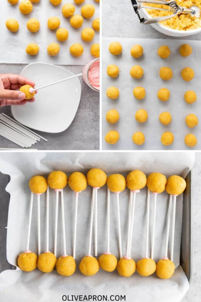 Rows of smooth yellow cake balls on parchment paper, with a hand dipping a cake pop stick into melted pink coating and inserting it into a cake ball, showing the step before chilling.
