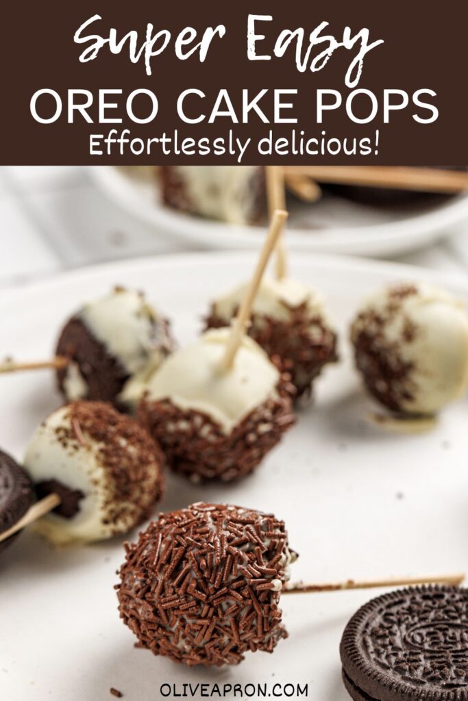 Oreo cake pops dipped in white chocolate and chocolate sprinkles on a serving plate.