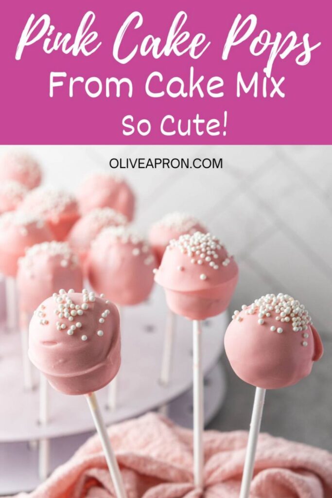 Pink cake pops displayed on a cake pop stand, topped with white sprinkles for a simple and adorable party dessert.