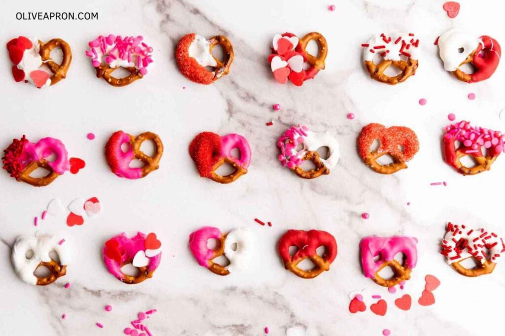 An assortment of Valentine pretzels decorated with sprinkles and candy.
