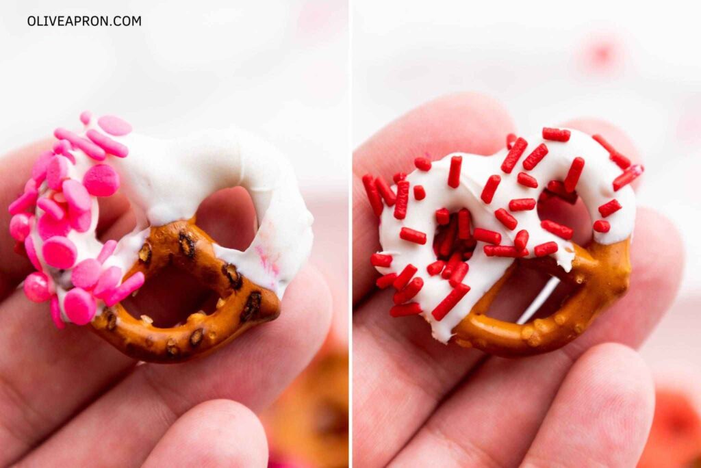 Handheld pink and red sprinkles decorated Valentine pretzels close up.