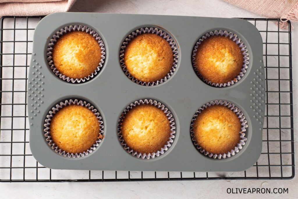 Baked cupcakes cooling on a wire rack
