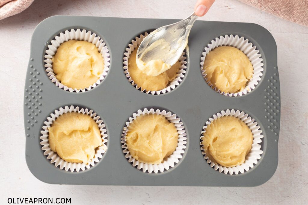 Filling muffin tins with half cupcake mixture