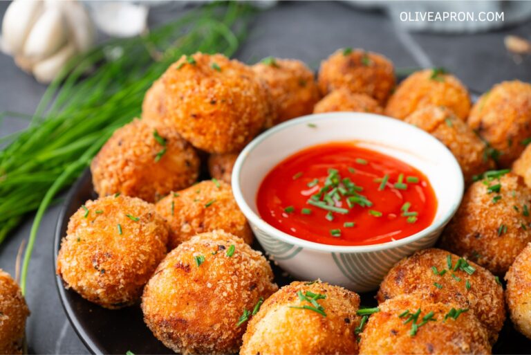 Mash potato bites served on a dish with tomato sauce