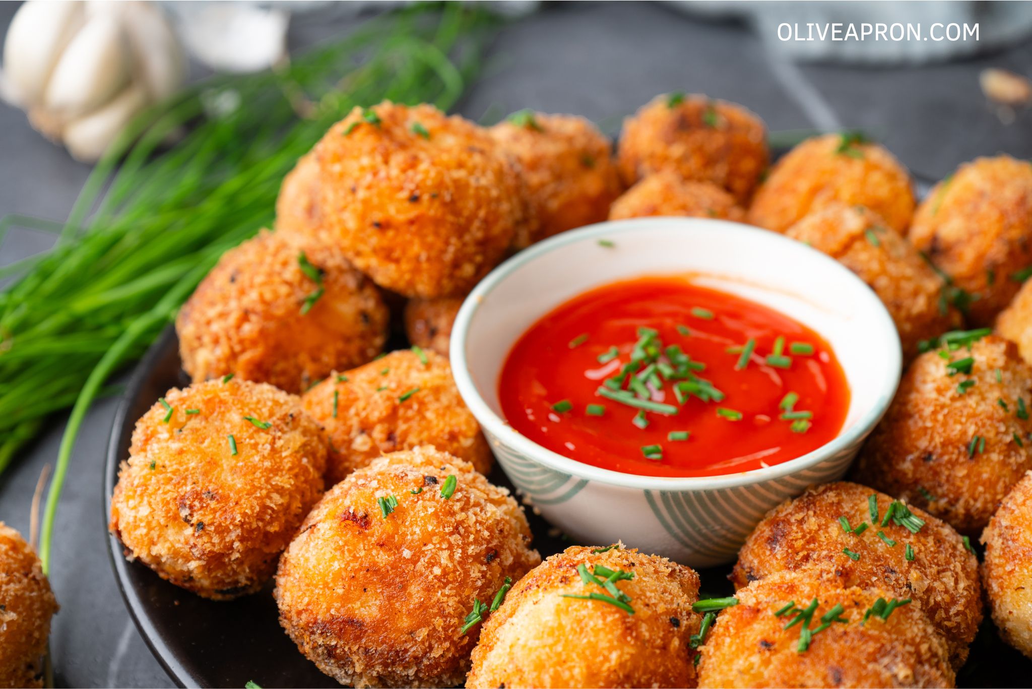 Mash potato bites served on a dish with tomato sauce