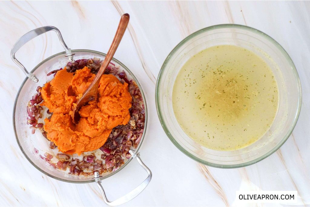 Pumpkin puree and broth is added it to the onion and garlic mixture