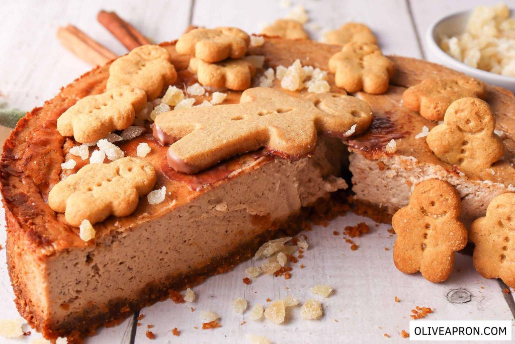 Cut gingerbread cheesecake adorned with small gingerbread men at the top